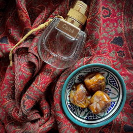 Where elegance meets tradition: Chloé's Nomade Eau de Parfum Naturelle with a touch of Middle Eastern charm, wrapped in rich textiles and the sweetness of dates.